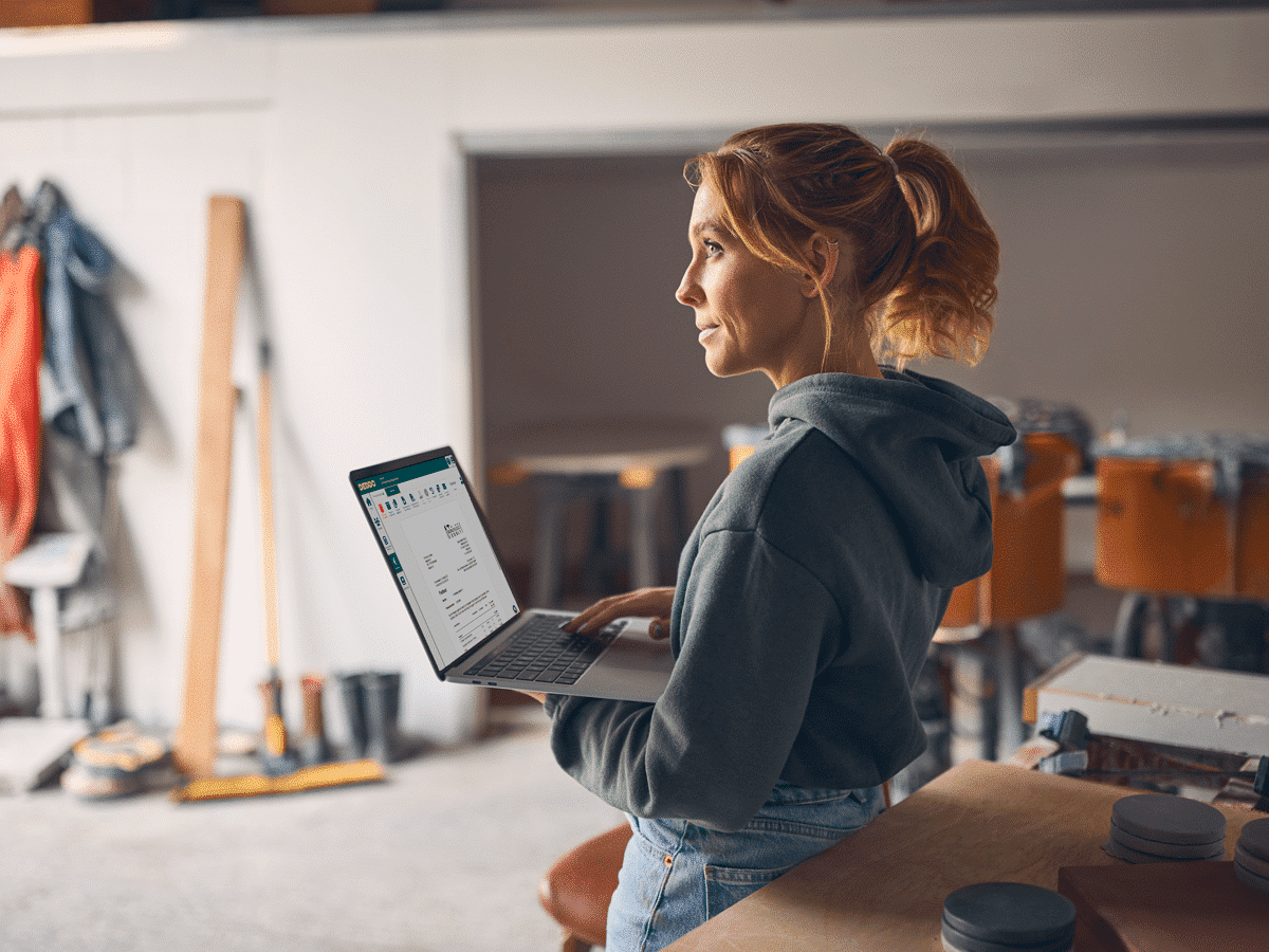 Vakvrouw in de werkplaats maakt een factuur met software DEDDO