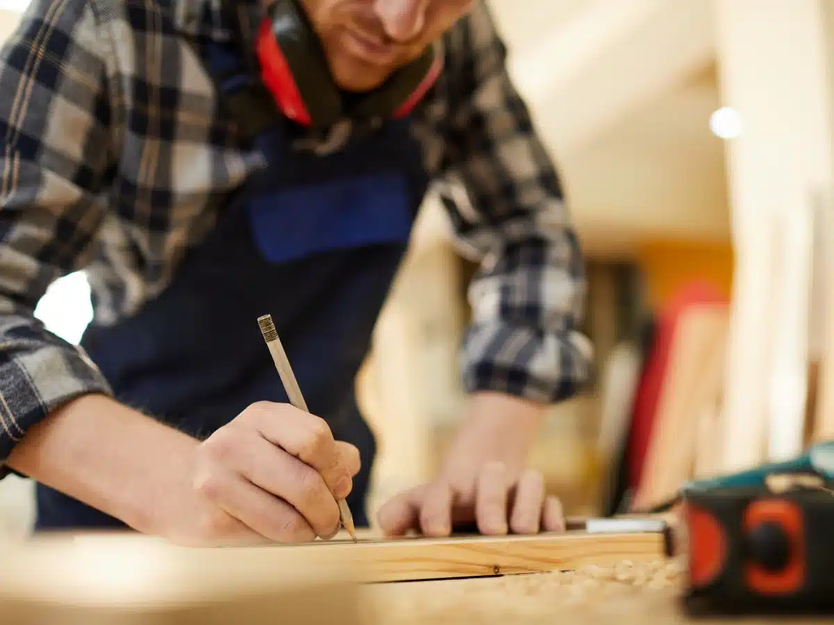 Aannemer meet het hout in de werkplaats op basis van de calculatie van de klus