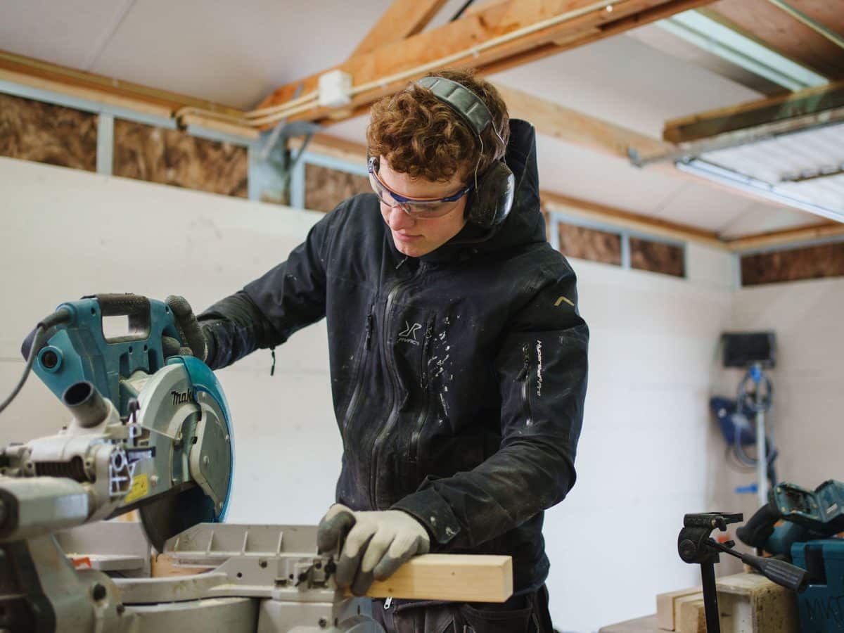 Aannemer zaagt hout in de werkplaats