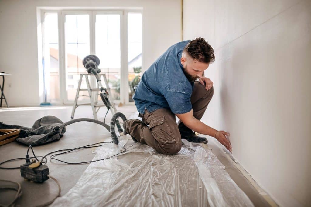 Muur schilder na het zorgvuldig calculeren van schilderwerk