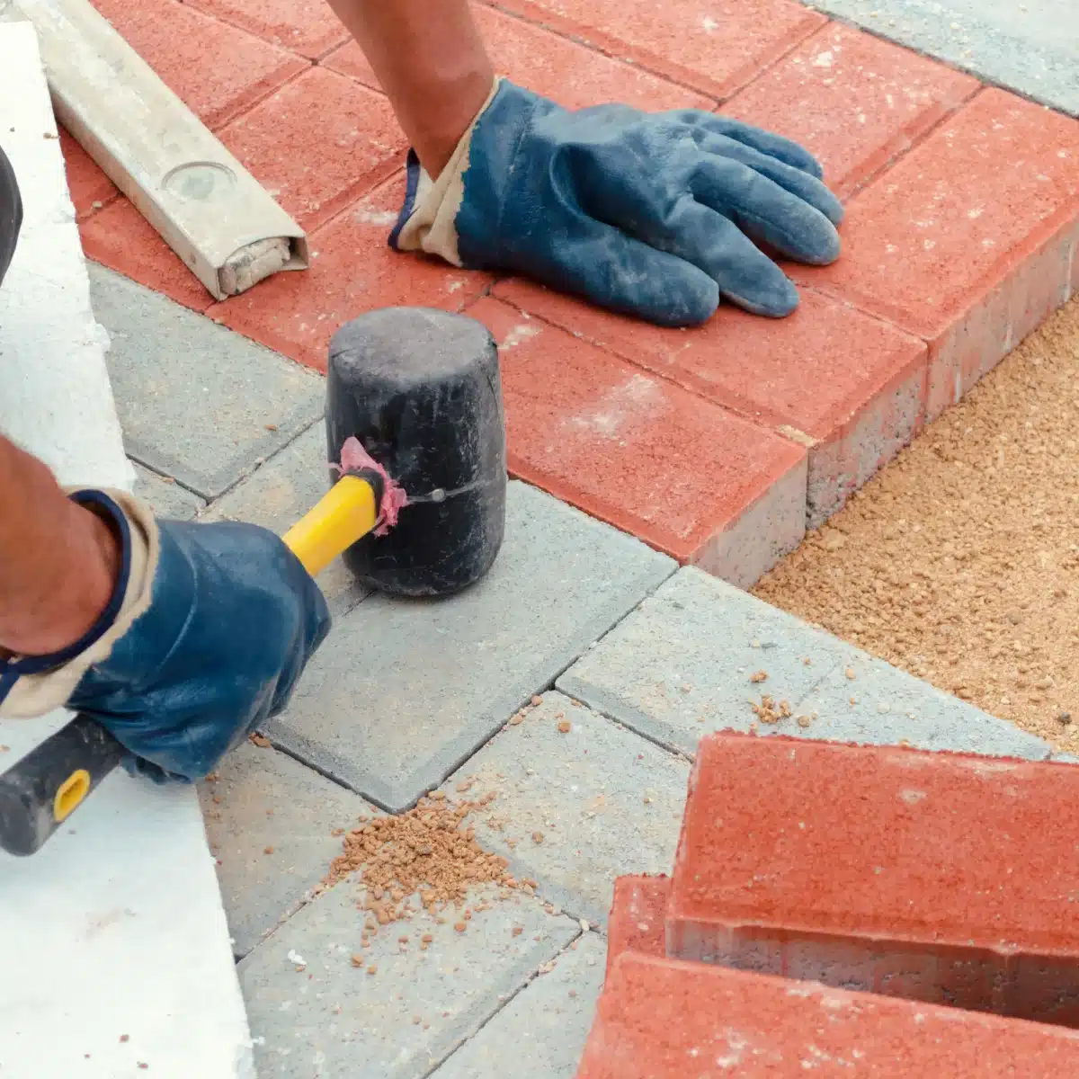Stratenmaker bezig met aanleg bestrating