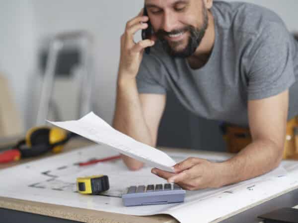 Timmerman tevreden aan het werk, papierwerk klussen aan het regelen