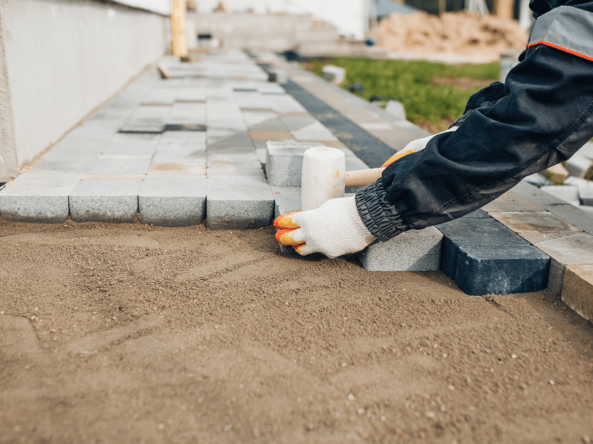 Hovenier legt bestrating in tuin aan