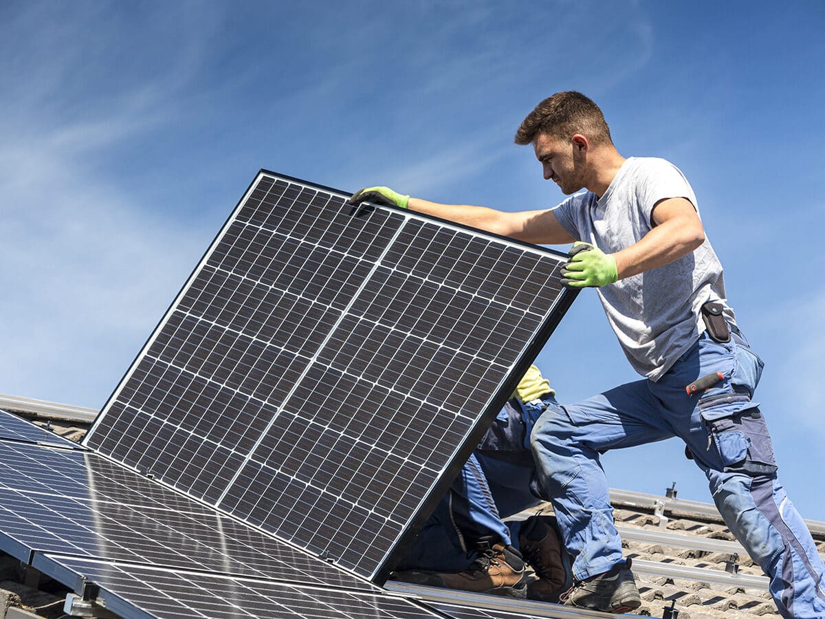 Installateur installeert zonnepanelen op het dak
